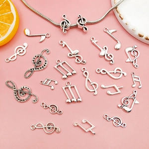 Detail of diverse silver musical note alloy charms on a soft pink background