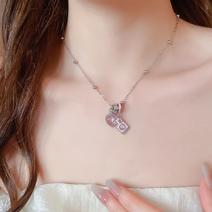 Close-up of a silver bead chain with pink heart crystal and enamel rectangle pendants
