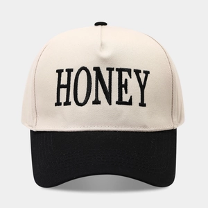 Casquette trucker bicolore crème et noire avec broderie HONEY sur le devant