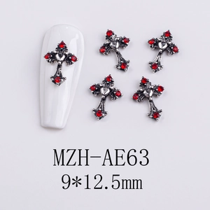 Detailed view of silver Gothic cross nail charm with a heart center and red rhinestones