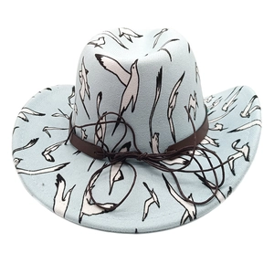 Close-up of bird prints and brown leather strap detail on a blue western cowboy hat