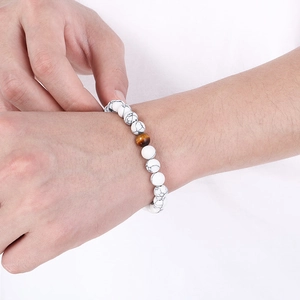 Close-up of white marble stone beads and brown tiger eye bead on elastic bracelet