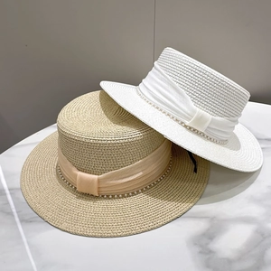 Elegant summer boater straw hats in beige and white with silk bands and pearl details