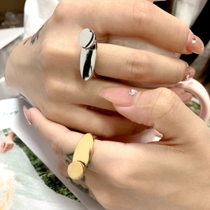Close-up of gold and silver geometric titanium steel rings worn while holding a cup
