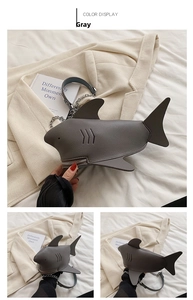 Detailed views of a grey shark-shaped leather bag with chain and fin accents