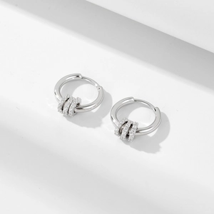 Elegant silver hoop earrings with three dangling cubic zirconia circles on white background