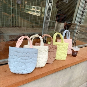 Detailed row of quilted mini handbags with large flower patterns in five pastel colors