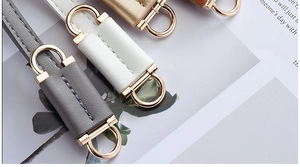 Flat lay of colorful thin PU leather waist belts with elegant gold D-ring buckles