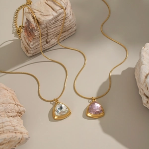 Detail of 18K gold plated stainless steel necklaces with clear and pink zircon pendants