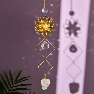 Golden suncatcher with natural raw crystal flower and hanging faceted prisms on a wall