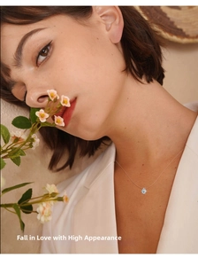 Close-up of a minimalist silver solitaire necklace with a round-cut diamond on a female neck