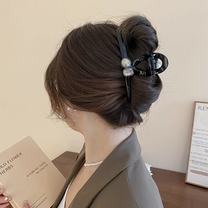 Detail of a large black claw clip with pearl and square crystal on hair