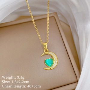 Detail of gold crescent moon and green heart crystal pendant necklace with size specs