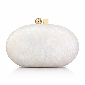 Detail of elegant pearl white marble acrylic clutch bag with luxury gold spherical clasp