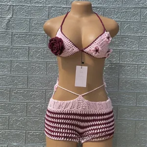 Detail of handmade crochet bikini with burgundy rose accent and pink stripe knit pattern