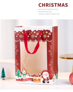 Detail der Weihnachts-Geschenktüte mit Fenster, rotem Seidengriff und festlichen Motiven