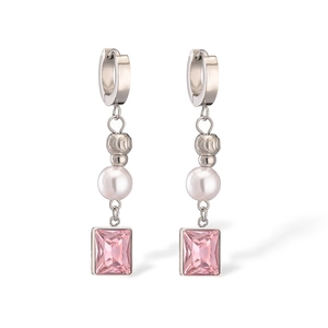 Detailed view of silver titanium steel earrings with pink zircon and pearl accents
