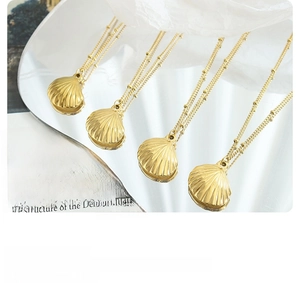 Detailed close-up of golden scallop shell pendant necklaces with delicate bead chain design