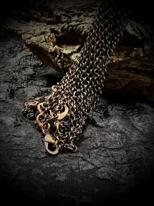 Detailed view of a 60cm vintage copper sweater chain with clasp on a dark wood background