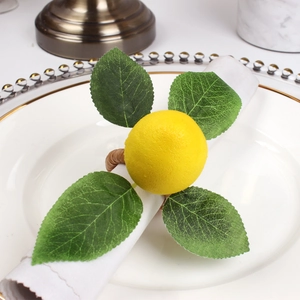 Detail of realistic yellow lemon napkin ring with green leaves on woven rattan loop