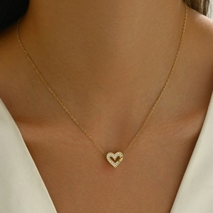 Elegant gold hollow heart pendant necklace with zircon stones on female model