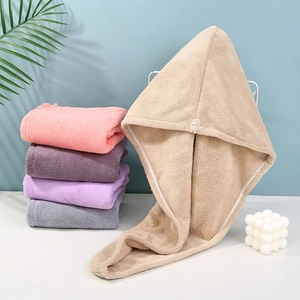 Macro detail of thick coral fleece hair towel wrap showing soft texture and button closure