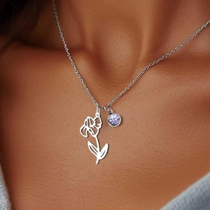 Silver necklace with floral pendant and purple gemstone shown on a fashion model
