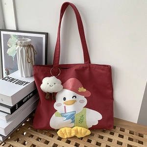 Detail of red canvas tote bag with cute duck print and white cloud plush charm