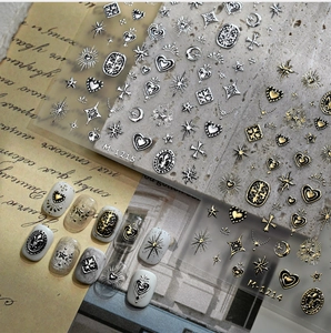 Detailed macro view of 3D embossed gold and silver nail stickers with gothic cross designs