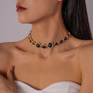 Close-up of vintage gold choker necklace featuring black resin geometric round charms