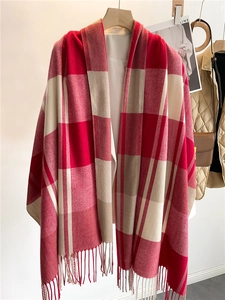 Dettaglio di sciarpa a quadri rossa e crema con frange e consistenza spessa tipo cashmere