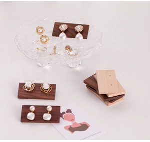 Detailed close-up of walnut wood earring display stand with pearl and rose jewelry