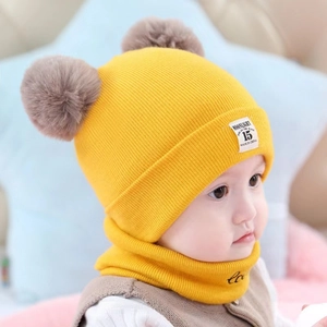 Cozy yellow knitted baby hat and scarf set with two brown faux fur pom poms