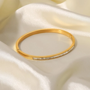 Dettaglio di un bracciale in acciaio inossidabile dorato con zirconi bianchi rettangolari