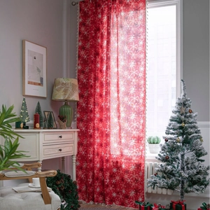 Red Christmas curtains with white snowflake pattern in a cozy festive home setting