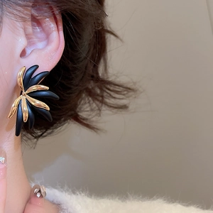 Detail view of vintage flower stud earrings with 18k gold plating on elegant model