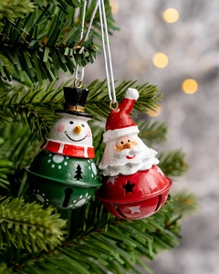 Macro view of Christmas bell ornaments with Santa and snowman on pine tree branches