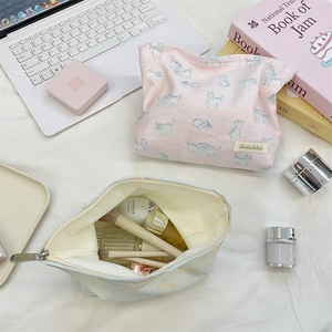 Detail view of large capacity cat print makeup bags in soft pink and blue canvas fabrics