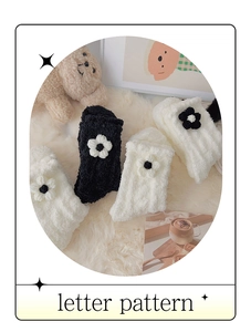 Detail von weichen Korallenvlies-Socken mit 3D-Blumendekor auf weißer Decke