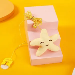 Detail view of yellow plush star toy with suction cup and elastic hanging cord for cats