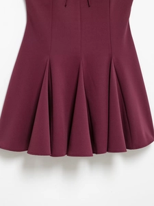 Detail shot of pleated burgundy dress fabric showing fine texture and deep wine red color