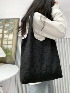 Detail view of the black embossed floral texture on this elegant shoulder tote bag
