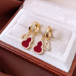 Macro shot of 14K gold plated red gourd earrings with hollow design and zircon inlay