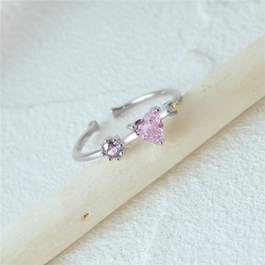 Detail of S925 silver open ring with pink heart stone and purple round crystal