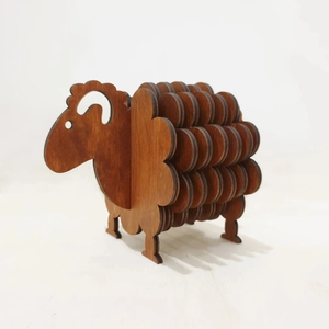 Detail showing the layered dark wood sheep coaster set with natural wood grain texture