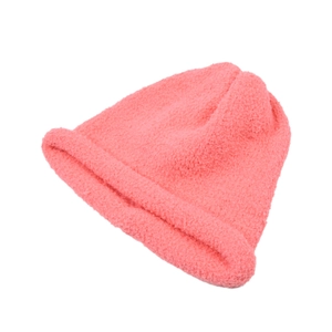 Dettaglio del berretto in maglia rosa con trama in lana d'agnello e bordo arrotolato