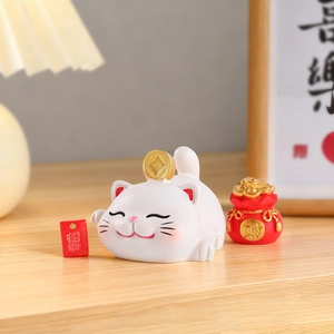 Vue détaillée du chat porte-bonheur avec sac de fortune rouge et enveloppes sur bois