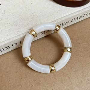 Detail of marble pattern resin segments and golden metallic spacer beads on the bracelet