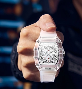 Macro shot of pink transparent tonneau watch with skeleton dial on wrist