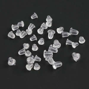 Macro shot of bulk transparent silicone earring backings on a dark grey background